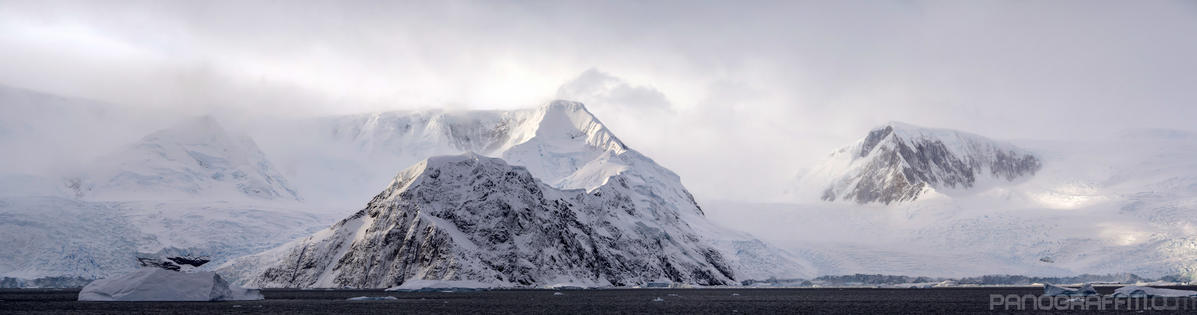Rocky Peninsula in Andvord Bay - A ridge emerges from the water to trace a path to the mountain top and direct the glacier on the left